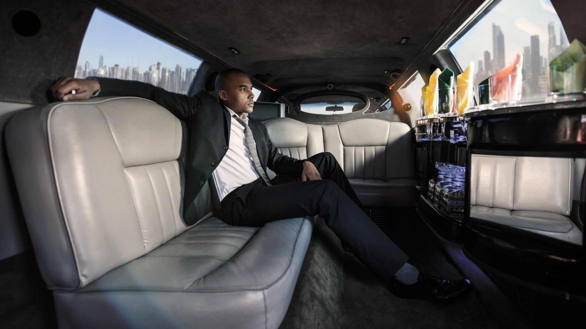 First-class executive passenger working inside luxury limousine cabin